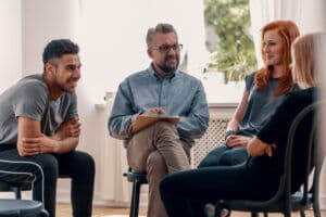 Group of people sitting during group substance use treatment therapy