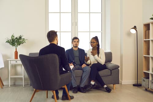 A couple sitting with their therapist