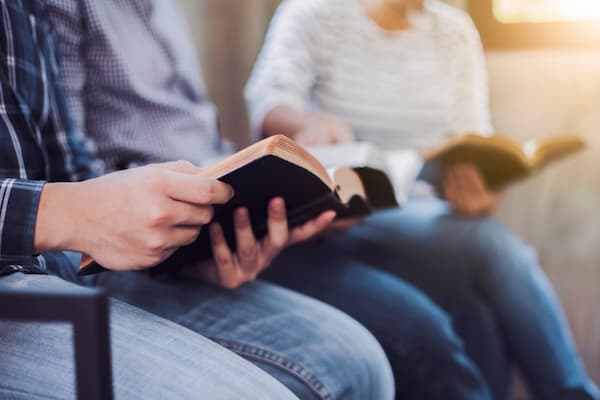 Group of people sitting and reading the bible