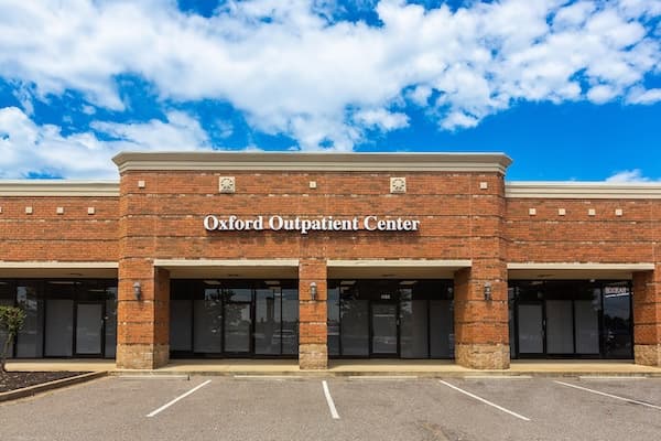 Brick commercial building with blue sky and clouds above