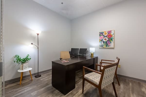 Therapist office with lamps and a desk and chair