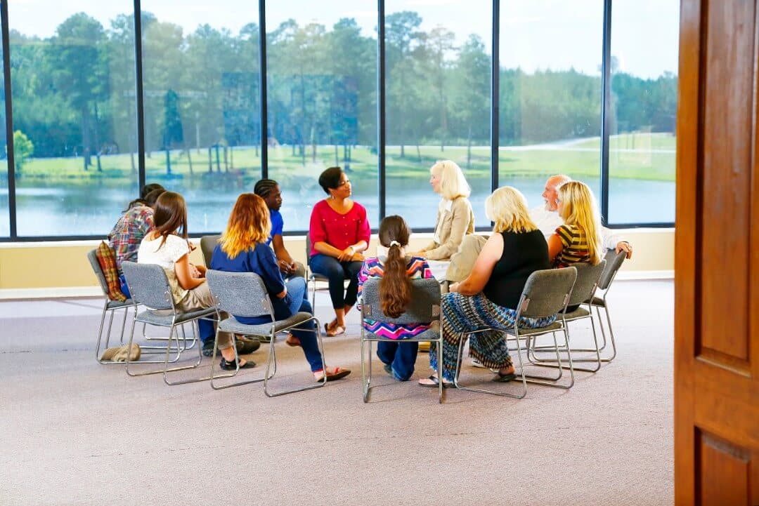 Group of people sitting in a circle in therapy