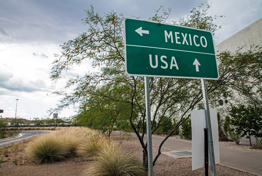 Highway sign with arrows pointing to Mexico and USA